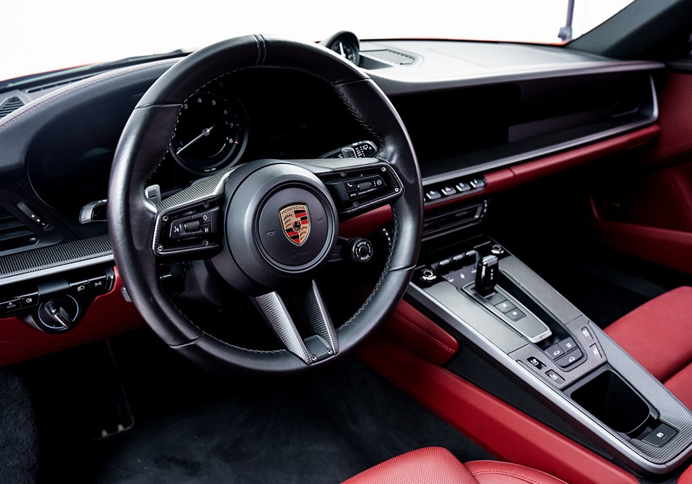 Full view of the Porsche 911 992.2 interior showcasing sleek carbon fiber trims across the dashboard, doors, and center console
