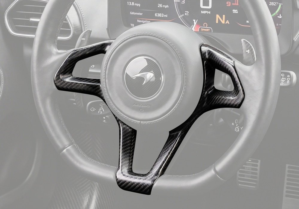 Full McLaren Artura steering wheel view featuring carbon fiber trim for a luxury and race-inspired look