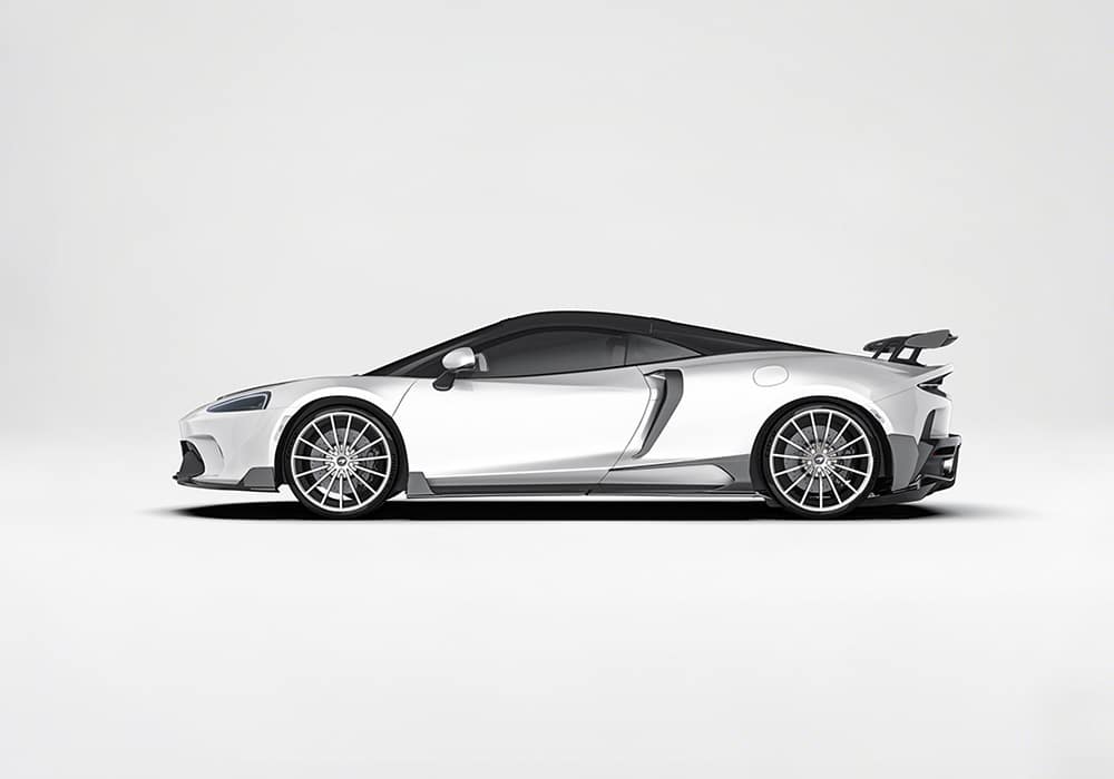 A detailed image highlighting the lightweight aerospace-grade carbon fiber side skirts with their polished finish and seamless fitment