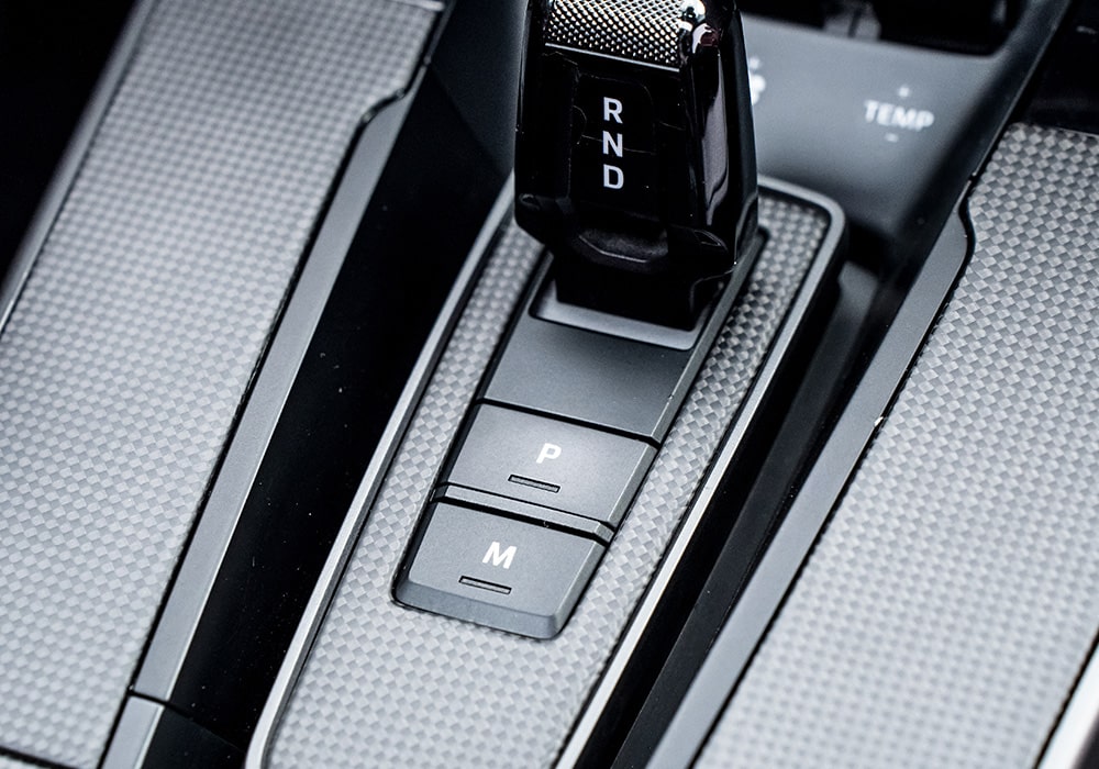 A close-up of the Porsche 911 992.2 steering wheel, upgraded with carbon fiber accents for a race-inspired touch