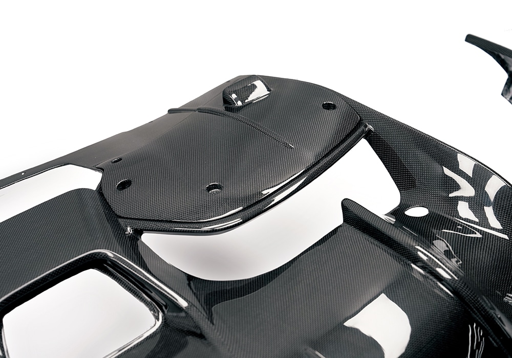 Studio image of Carbon Fiber Rear Diffuser for Ferrari Purosangue showing aerodynamic fins and curved profile