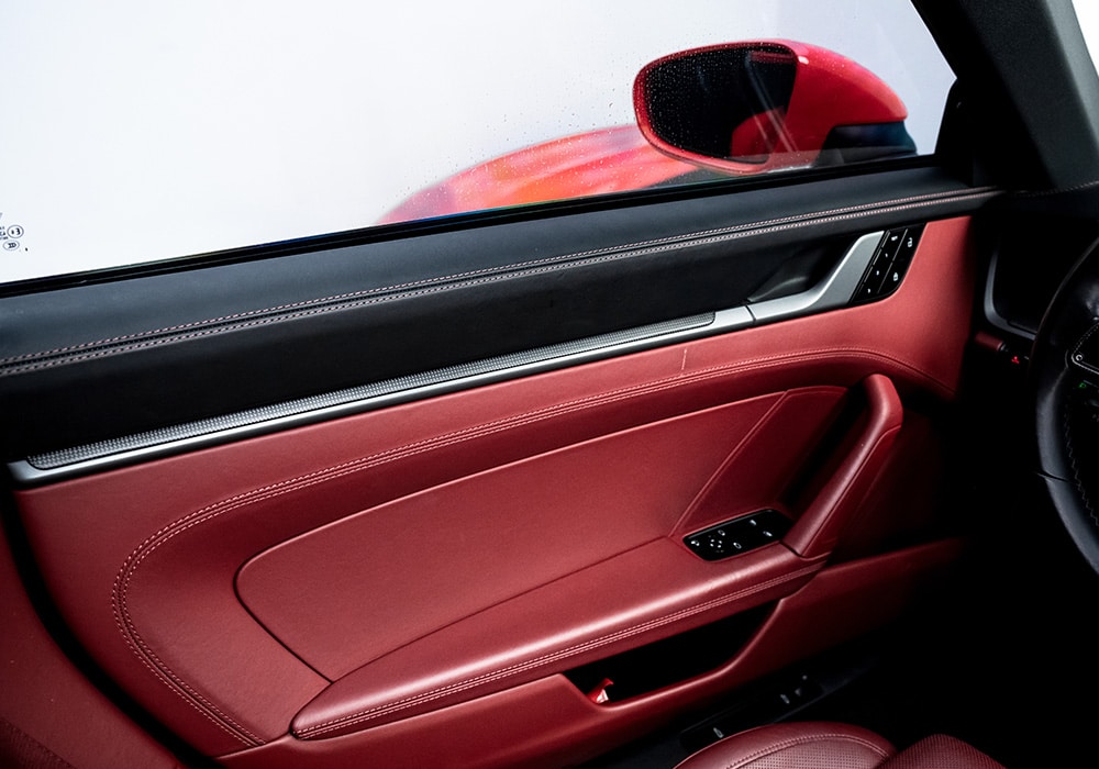A close-up of the carbon fiber center console trim, highlighting its perfect fitment and superior craftsmanship in the Porsche 911