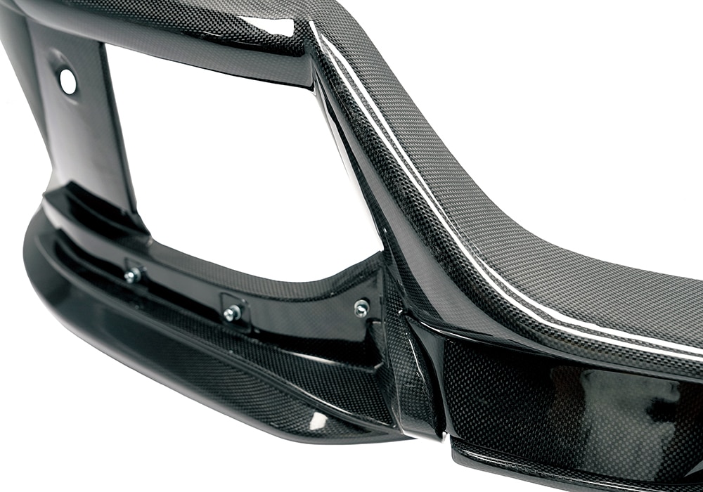 Ferrari Purosangue driving on a scenic road, with Carbon Fiber Front Lip optimizing aerodynamic efficiency