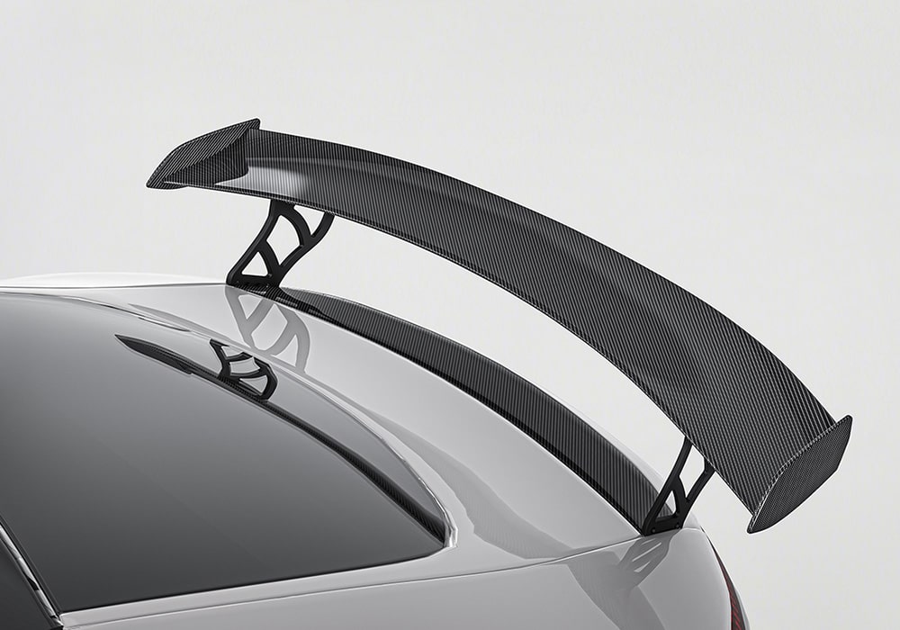 Images of the individual components laid out – front lip, rear diffuser, side skirts, and spoiler – neatly shown to illustrate the contents of the Carbon Fiber Aero Kit