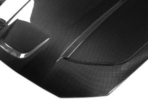 A side-by-side visual comparison showing the weight difference, enhanced aerodynamics, and sharper styling between the stock hood and the BMW M3 G80 Carbon Fiber Hood