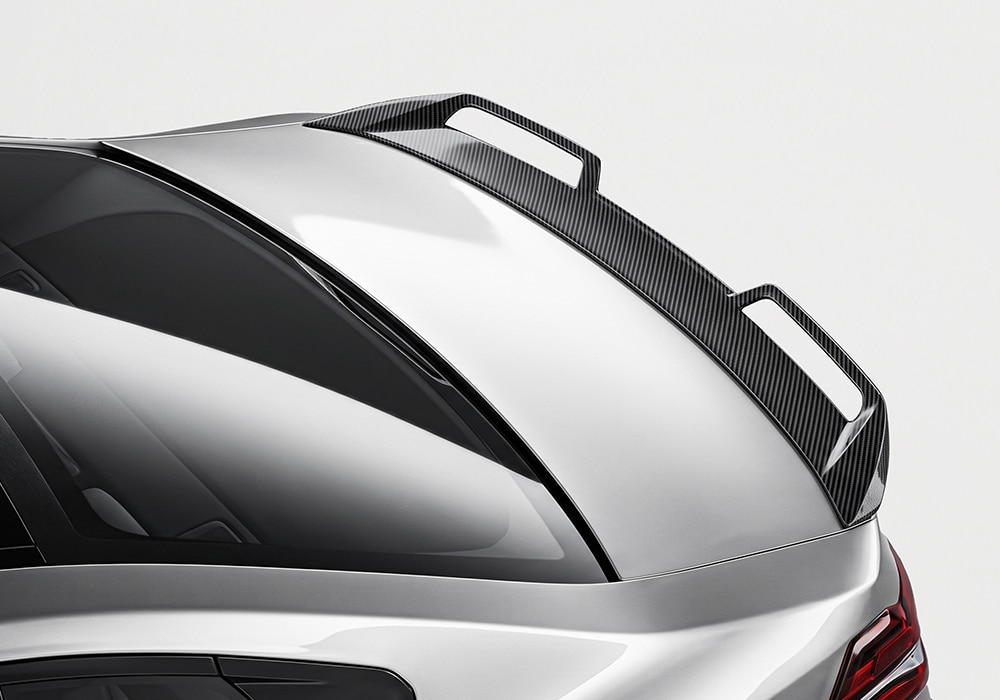 BMW M5 (G90) featuring a full carbon fiber aero kit, including front lip spoiler, side skirts, diffuser, and roof spoiler, enhancing its aggressive stance