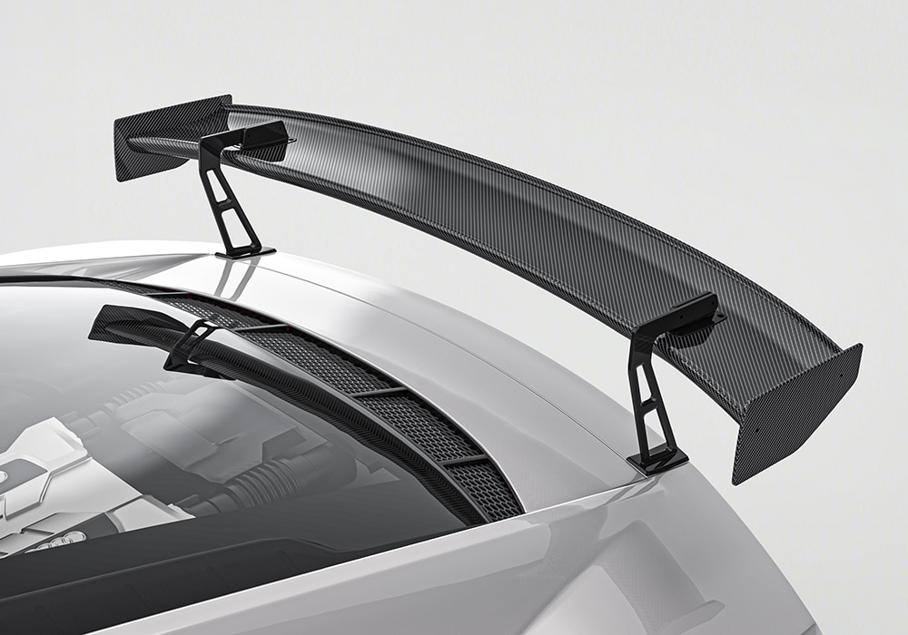 Audi R8 showcasing the full carbon fiber aerodynamic package including side skirts, wing spoiler, and splitters